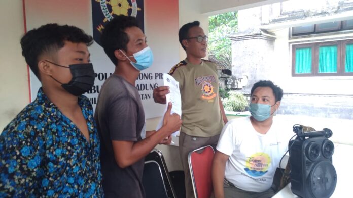 Dua orang pemuda yang ditertibkan Satpol PP karena melakukan aktivitas karaoke di simpang traffick light di Kuta.